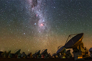 Foto do observatório ALMA (Atacama Large Millimeter/submillimeter Array), do ESO, com a Via Láctea visível sobre os radiotelescópios. O IA é um Centro de Competências para o ALMA. Crédito: ESO/B. Tafreshi